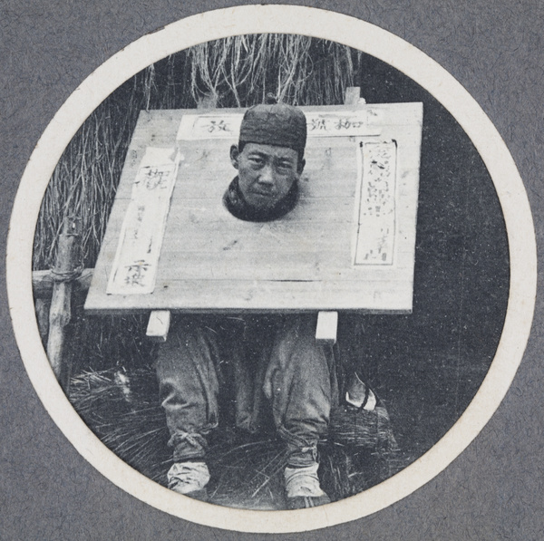 A man wearing a cangue as a punishment
