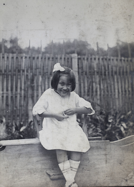 Girl sitting on a wooden seat in the garden, 35 Tongshan Road, Hongkou, Shanghai