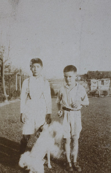 Fred Hutchinson and unidentified boy with a dog in the garden, 35 Tongshan Road, Hongkou, Shanghai