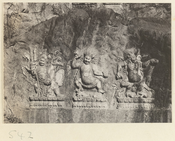 Three Buddhist relief figures, two with headdresses of skulls, at Yuquan Hill