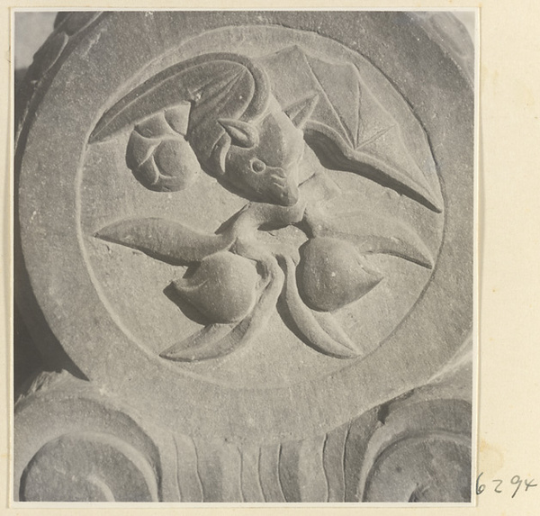 Carved door stone with bat and peach motifs