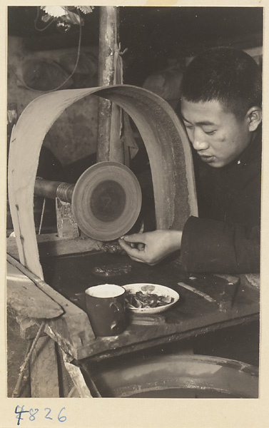 Man using a grinding wheel to polish jade in a workshop