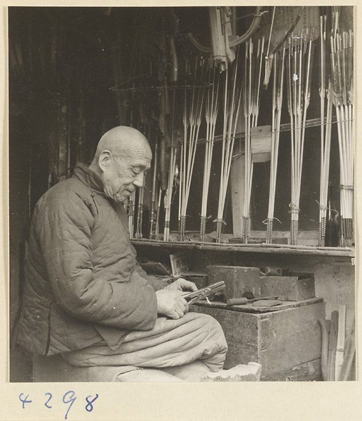 Man at work in a bow-and-arrow-making shop
