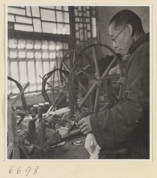 Man spinning cotton in a workshop
