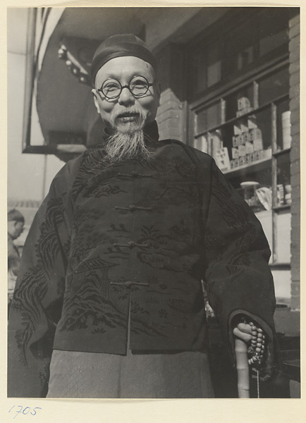 Man in silk jacket standing outside shop