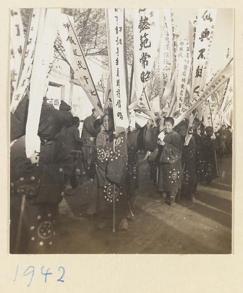 Members of a funeral procession carrying banners with elegiac inscriptions presented by friends and colleagues
