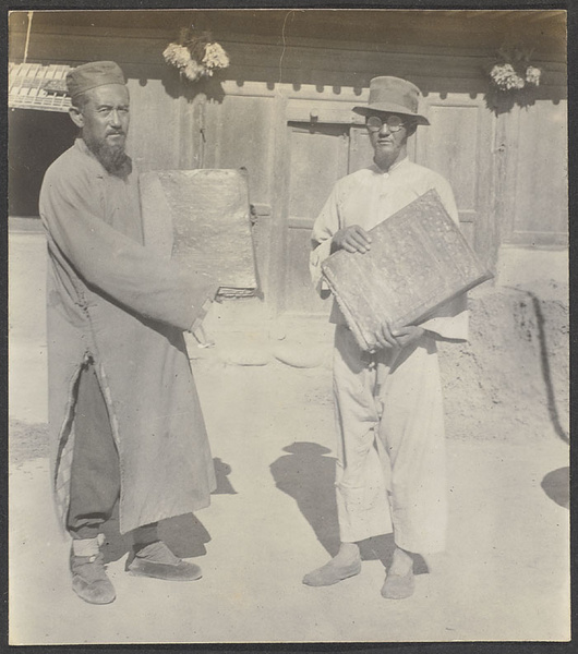 Kehtsikung, Tsinghai.  Two Salar farmers holding the holy Koran with unclean hands.
