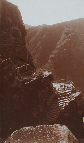 Mountain porter carrying furniture, with telegraph wires