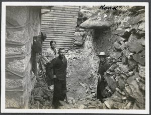 Workmen constructing a retaining wall by a road