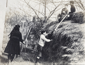 Maggie, Dick and Fred Hutchinson, and neighbouring boy, playing around a haystack, Hongkou, Shanghai