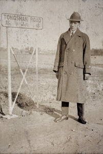 Bill Hutchinson wearing an overcoat, standing beside a Tongshan Road sign, Hongkou, Shanghai