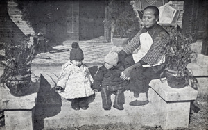 An amah sitting with Bea and Sonny Hutchinson on verandah steps, 35 Tongshan Road, Hongkou, Shanghai