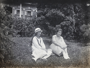 Maggie and Sarah Hutchinson sitting on a garden lawn, Shanghai