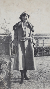 Molly Noble, wearing a winter coat and hat, standing in the garden, 35 Tongshan Road, Hongkou, Shanghai