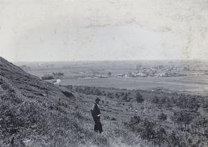 Harry Hutchinson standing on a hillside above the old city wall and fields, near Kunshan