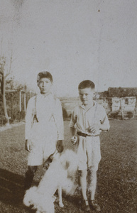 Fred Hutchinson and unidentified boy with a dog in the garden, 35 Tongshan Road, Hongkou, Shanghai