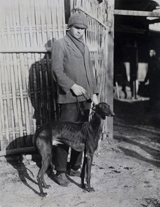 Mr W. G. Crokam with a greyhound on a chain leash, Kalgan Dairy Farm, Shanghai 