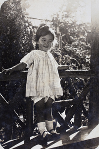 Bea Hutchinson standing on the seat of the garden summer house, 35 Tongshan Road, Hongkou, Shanghai, July 1924 