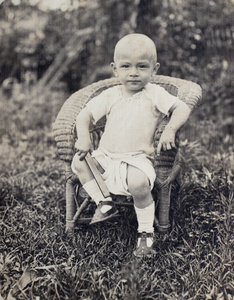 Sonny Hutchinson sitting on a small wicker chair in the garden of 35 Tongshan Road, Hongkou, Shanghai