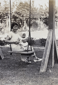Georgina Kirby sitting on the garden swing holding her baby daughter, 35 Tongshan Road, Hongkou, Shanghai 