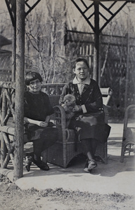 Unidentified girl and woman sitting with a poodle dog in the summerhouse, 35 Tongshan Road, Hongkou, Shanghai