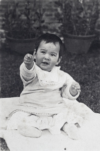 Bea Hutchinson sitting up on a baby quilt in the garden, 35 Tongshan Road, Hongkew, Shanghai