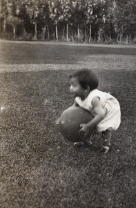Gladys Hutchinson playing with a large ball in the garden, 35 Tongshan Road, Hongkou, Shanghai 