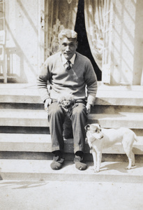 William Hutchinson sitting on the front steps with two dogs, 31 Lucerne Road, Shanghai