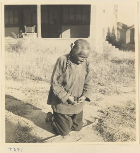 Woman kneeling outside a building in Baoding