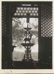 Candlestick silhouetted in a window at Da jue si