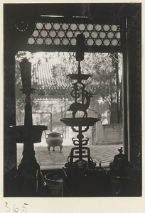 Candlesticks and other ritual objects from an altar silhouetted in a window at Da jue si