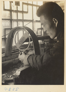 Man using a grinding wheel to polish jade in a workshop