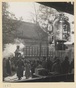 People, lantern, and burning incense outside Bai yun guan at New Year's