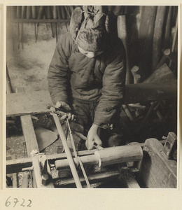 Carpenter turning a piece of wood at a lathe