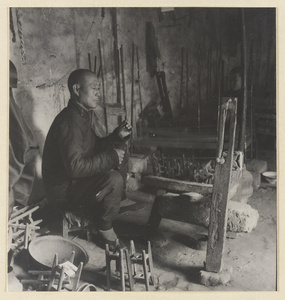 Man spinning silk in a workshop
