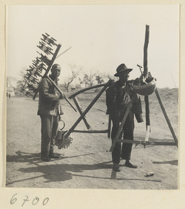 Men with silk-spinning equipment outdoors