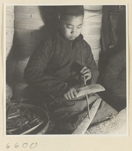 Boy cutting slats for bamboo steamers in a workshop