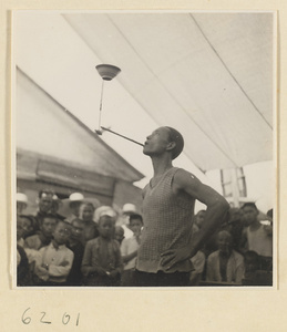 Acrobat performing a balancing act in front of a crowd at Tianqiao Market