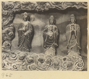 Interior detail of a cave temple at Yun'gang showing a niche with three standing Bodhisattvas