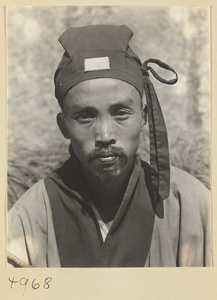Daoist priest wearing a cap with a jade plaque and a streamer knot on Hua Mountain.