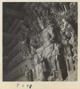 Interior of a temple building at Ling yan si showing statues of a Buddha and attendants