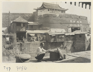 Man with shoulder pole in front of city gate of Tai'an