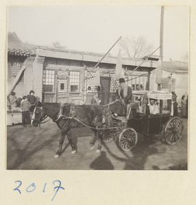 Women in a horse-drawn carriage following a coffin in a funeral procession