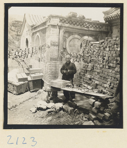 Man selling souvenirs outside temple building on Miaofeng Mountain