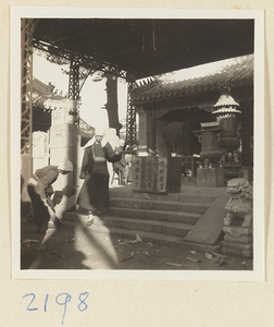 Pilgrims with incense under a canopy at the entrance to a temple building on Miaofeng Mountain