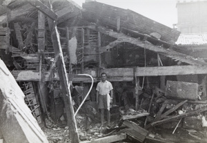 Men among debris in an upper storey of the Palace Hotel, Shanghai, after the bombing on 14 August 1937
