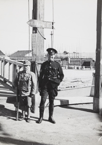 A Shanghai Municipal Police sergeant with a soldier by a bridge, Shanghai, 1937