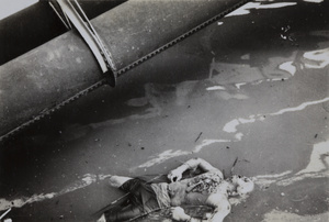The corpse of a man, floating in Soochow Creek under Kiangse Road Bridge, Shanghai, August 1937