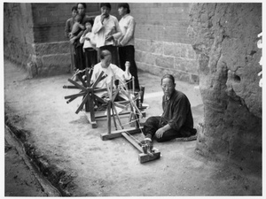 Women spinning cotton by hand, in a street, 1938