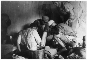 Three men treating a patient at Dr Norman Bethune (白求恩)'s hospital
